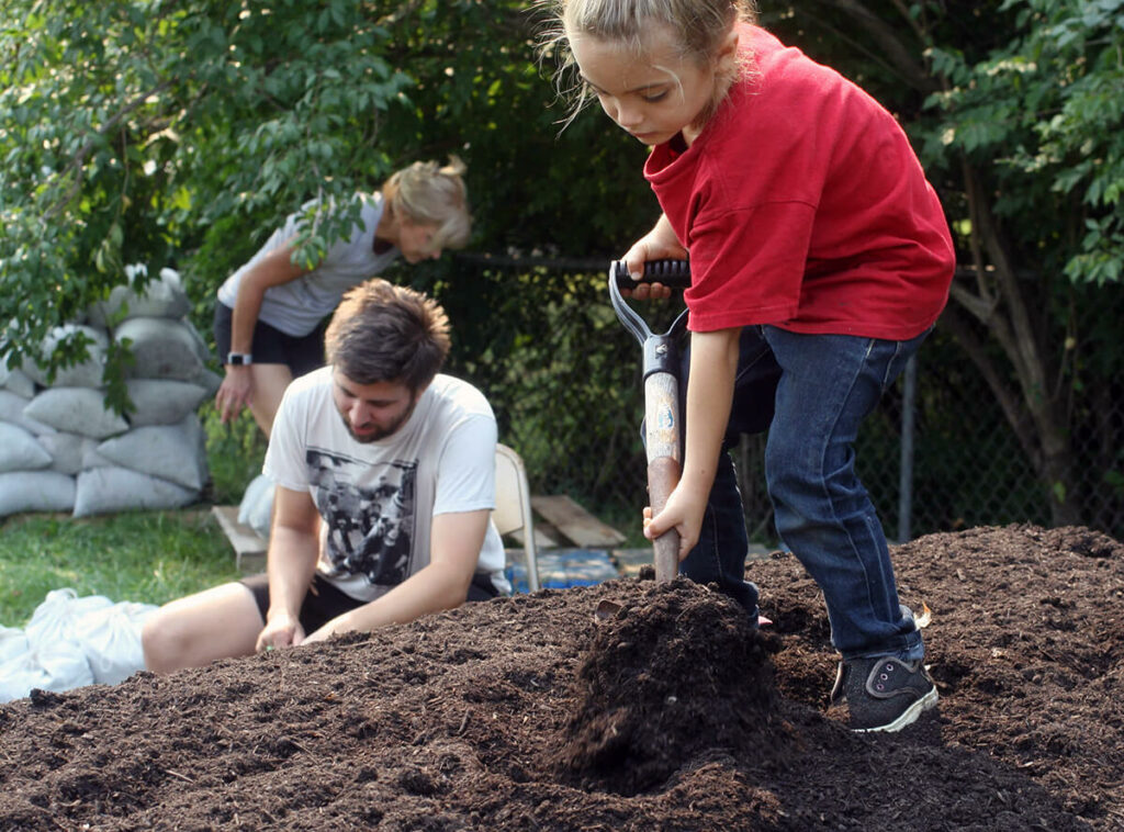 Child shoveling compost